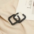 Detail of square black fabric-wrapped hoop earrings with woven texture on satin background - Rectangle / Black Velvet