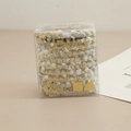 Détail d'élastiques à cheveux en laine multicolore douce dans une boîte minimaliste - Série Beige