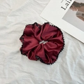 Detail eines bordeauxroten Satin-Haargummis mit feinem Perlenrand und Seidenglanz - Weinrotes Scrunchie