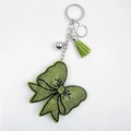 Détail du porte-clés nœud en cristal vert avec clochette et pompon en cuir - Vert clair