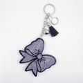Détail du porte-clés nœud en cristal étincelant avec pompon en cuir noir et violet - Mauve Clair