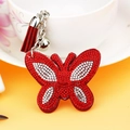 Portachiavi farfalla con strass rossi, nappa e campanello vicino a una tazza bianca - 65*55mm / Rosso