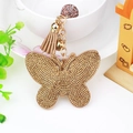 Detail of butterfly keychain with champagne rhinestones, brown leather tassel and gold ball - Khaki