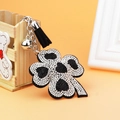 Sparkling four-leaf clover keychain with rhinestones, black leather tassel and silver bell - Black With White Rhinestone