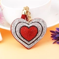 Detail showing heart-shaped rhinestone keychain with layered crystals and a red tassel - Red