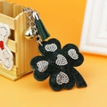 Sparkling dark green clover keychain with leather tassel and silver bell decoration - Green