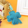 Detail of blue rhinestone clover keychain with golden bell and light blue tassel charm - Lake Blue