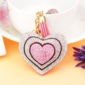 Close-up of heart keychain with pink tassels and sparkling multicolored rhinestones - Pink