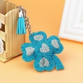 Detail of four-leaf clover keychain with sparkling blue rhinestones and leather tassel - Light Blue