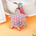 Detailansicht eines rosa Schildkröten-Schlüsselanhängers mit Kristallen und Lederquaste - Rosa