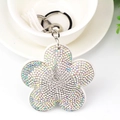 Dettaglio portachiavi a forma di fiore con strass di cristallo e nappa in pelle scamosciata - Bianco