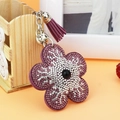 Détail du porte-clés tournesol violet avec des strass étincelants et un pompon en franges - Violet