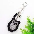 Detail view of a black velvet owl keychain with sparkling rhinestones and a silk tassel - Black