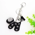 Detail of a black velvet dog keychain with white rhinestones, silver bell and tassel - Black