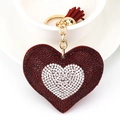 Dettaglio portachiavi a cuore rosso con strass e nappa su una tazza di ceramica - Rosso Scuro