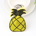 Portachiavi ad ananas in velluto con strass gialli e neri sul bordo di una ciotola bianca - Giallo