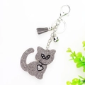 Detail view of gray rhinestone cat keychain with faux suede tassel and silver bell charms - Gray
