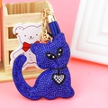 Close-up of dark blue rhinestone cat keychain with golden bell and fringe tassel - Sapphire Blue