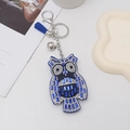 Detailed view of blue and white owl rhinestone keychain with fiber tassel and silver bell - Sapphire Blue