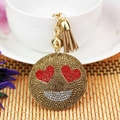 Dettaglio portachiavi emoji con occhi a cuore in strass e nappa in pelle marrone e oro - Stile Cuore / Cachi