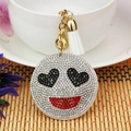 Dettaglio di un portachiavi emoji con strass scintillanti, occhi a cuore e nappa bianca - Stile Cuore / Bianco