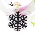 Sparkling snowflake keychain with white rhinestones and black fringe tassel on a cup - Black