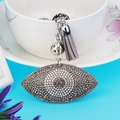 Vue détaillée d'un porte-clés en forme d'œil avec strass et gland en cuir gris élégant - Gris