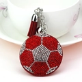 Gros plan d'un porte-clés de football en strass avec glands rouges et cloche argentée - Rouge