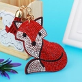 Detalle de llavero de zorro rojo y blanco con pedrería brillante y borla a juego - Rojo