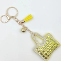 Portachiavi mini borsa gialla con cristalli quadrati verdi e nappa su sfondo bianco - Giallo