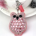 Pink owl keychain with glass rhinestones and leather tassel displayed on floral cup - Pink