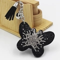 Dettaglio di un portachiavi a farfalla con strass lucidi, nappa nera e campanellino argento - Nero