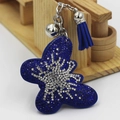 Détail d'un porte-clés papillon avec strass bleus, petite clochette et pompon en daim - Bleu Saphir