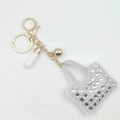 Mini handbag keychain with sparkling white rhinestones and white tassel in gold finish - White