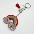 Dettaglio portachiavi arcobaleno con strass, nappa rossa e sfere in metallo argento - 60*45mm / Rosso