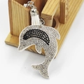 Detail showing dolphin keychain with white rhinestones and a white leather tassel - White
