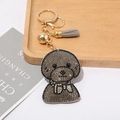 Détail d'un porte-clés caniche en strass gris avec anneau doré et pompon doux - Gris