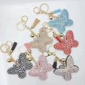 Detail of butterfly crystal keychains with glittering rhinestones and colorful leather tassels - Multicolor