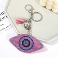 Detail of pink and blue rhinestone evil eye keychain with small tassel and bell accessories - Pink