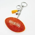 Dettaglio portachiavi da rugby con strass brillanti, nappa gialla e moschettone in metallo - Rugby Arancione