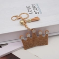 Sparkling crown keychain with crystal rhinestones, golden metal chain and brown tassel charm - Caramel color