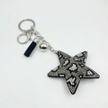 Detailed close-up of leopard pattern star keychain with crystal rhinestones and tassel charm - Gray