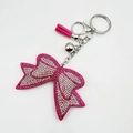 Dettaglio del portachiavi a fiocco con strass rosa, nappa in camoscio e campanellino - Rosa Rosso & Bianco