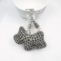 Dettaglio portachiavi a forma di cane con strass grigi, campanellino e nappa in pelle - Grigio