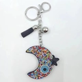 Close-up of colorful rhinestone crescent moon keychain with black tassel and silver bell - Multi-color