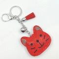 Detail of red rhinestone cat keychain featuring leather tassel and silver bell accessory - Red