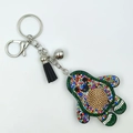 Macro detail of avocado rhinestone keychain with leather tassel and silver keyring - Multi-color