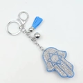 Funkelnder Hamsa-Hand Schlüsselanhänger mit hellblauen Strasssteinen und Seidenquaste - Himmelblau