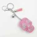 Detailed view of pink rhinestone skull keychain with silver bell and leather tassel - Pink