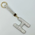 Detailed close-up of luxury H-shaped keychain with silver rhinestones and gold ring - Style H